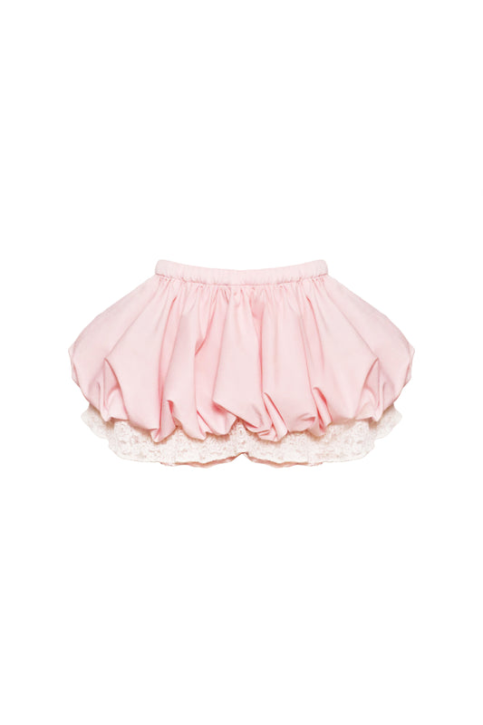 A pink Milk Blossom Skirt with floral lace detailing at the hem and a garterized waistband, designed for children.